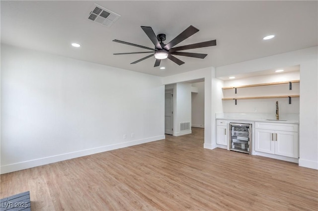 2107 Fountain Springs Dr, Henderson, NV 89074 - unfurnished living room featuring wine cooler, wet bar, recessed lighting, light wood finished floors, and ceiling fan