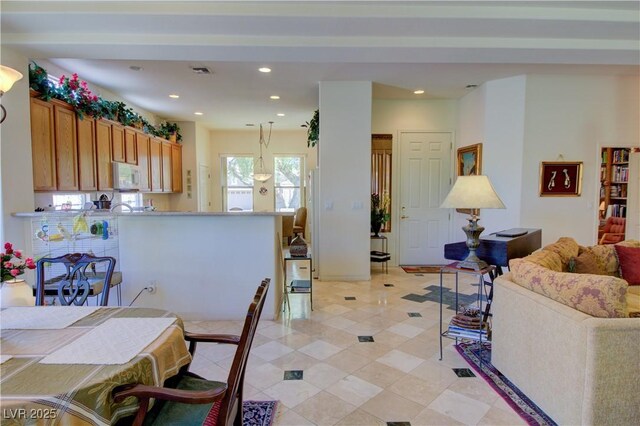 2026 Poppywood Ave, Henderson, NV 89012 - kitchen featuring white microwave, recessed lighting, brown cabinets, pendant lighting, and light tile patterned floors