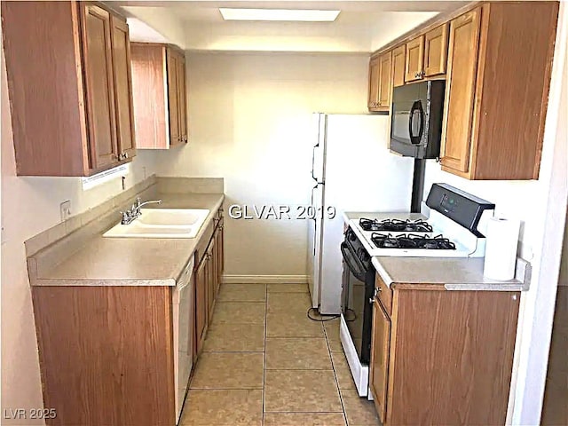 8417 Running Deer Ave Unit 101, Las Vegas, NV 89145 - kitchen with black microwave, gas range oven, brown cabinetry, light countertops, and light tile patterned flooring