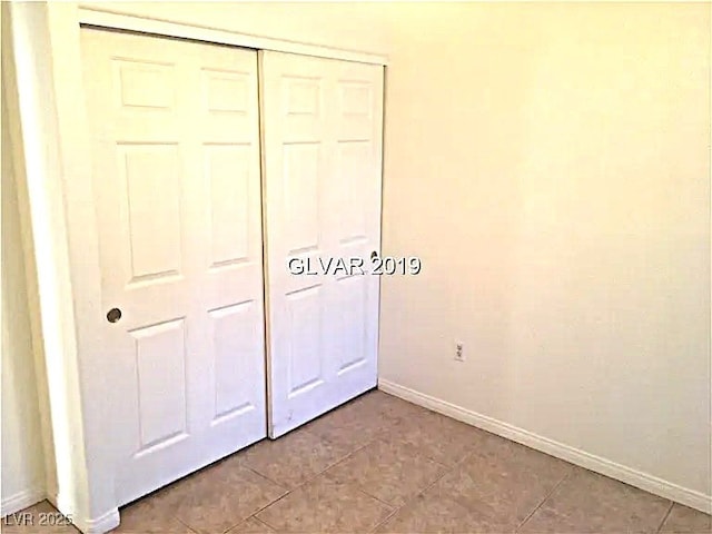 8417 Running Deer Ave Unit 101, Las Vegas, NV 89145 - unfurnished bedroom with a closet and tile patterned flooring