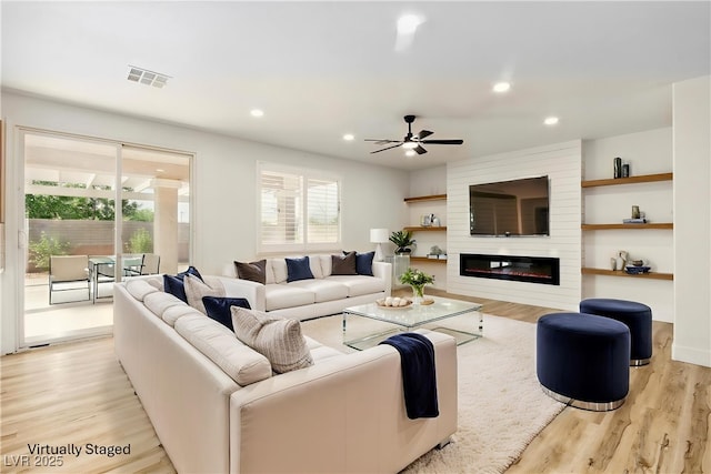 10302 Artful Stone Ave, Las Vegas, NV 89149 - living area with light wood-style flooring, ceiling fan, recessed lighting, and a large fireplace