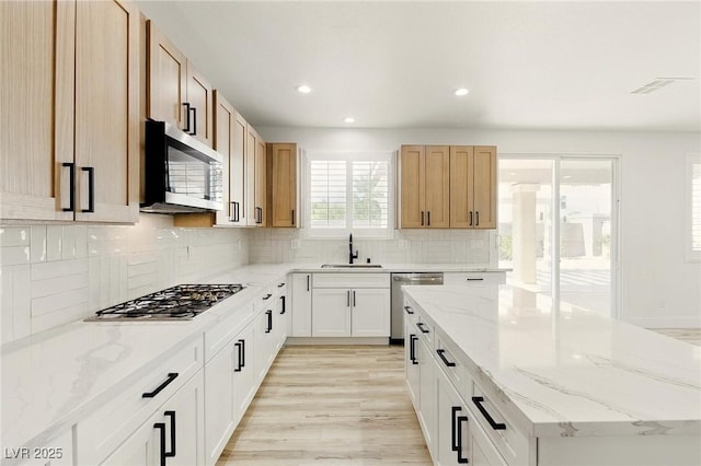 10302 Artful Stone Ave, Las Vegas, NV 89149 - kitchen with appliances with stainless steel finishes, a kitchen island, recessed lighting, tasteful backsplash, and light stone countertops