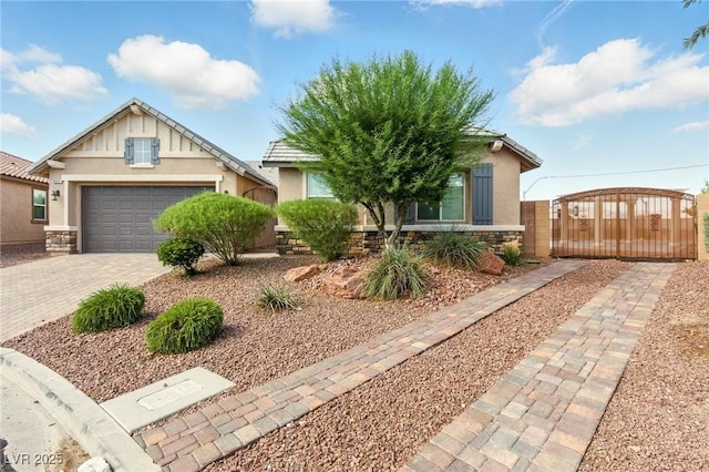 10302 Artful Stone Ave, Las Vegas, NV 89149 - view of front of home with stucco siding, stone siding, a gate, an attached garage, and driveway