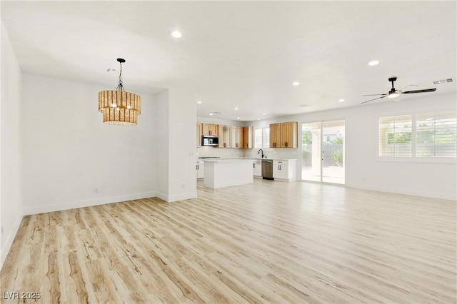 10302 Artful Stone Ave, Las Vegas, NV 89149 - unfurnished living room featuring recessed lighting, light wood-type flooring, a chandelier, and a ceiling fan