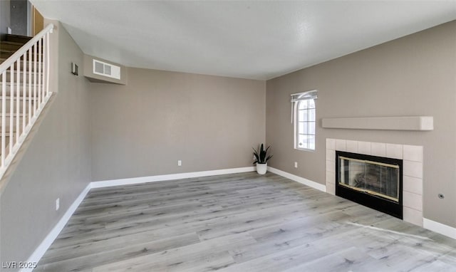 507 Satin Saddle Pl, Henderson, NV 89052 - unfurnished living room with a tile fireplace, wood finished floors, and stairs