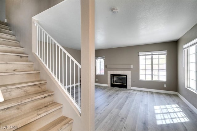 507 Satin Saddle Pl, Henderson, NV 89052 - staircase with wood finished floors, a tiled fireplace, and a textured ceiling