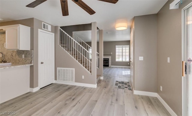 507 Satin Saddle Pl, Henderson, NV 89052 - foyer with a ceiling fan, light wood finished floors, a fireplace, and stairs