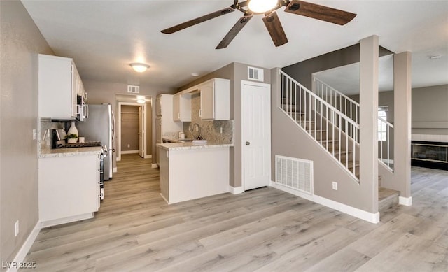 507 Satin Saddle Pl, Henderson, NV 89052 - kitchen with a ceiling fan, tasteful backsplash, stainless steel range with gas stovetop, white cabinetry, and light wood-type flooring