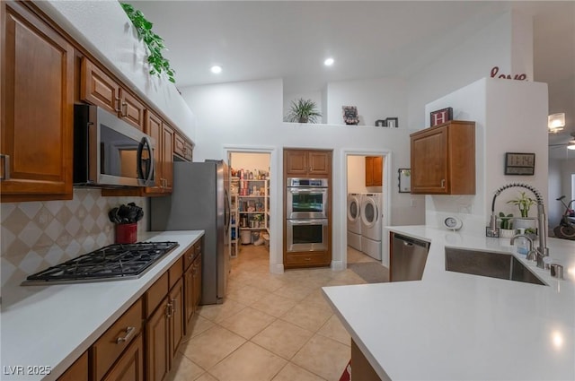 2640 Torch Ave, North Las Vegas, NV 89081 - kitchen with appliances with stainless steel finishes, independent washer and dryer, backsplash, light countertops, and brown cabinets