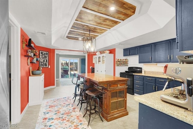 5008 Donnie Ave, Las Vegas, NV 89130 - kitchen featuring black stove, a raised ceiling, light stone counters, and pendant lighting