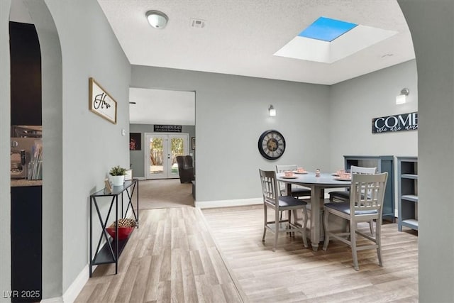 5008 Donnie Ave, Las Vegas, NV 89130 - dining space with a skylight, wood finished floors, arched walkways, and french doors
