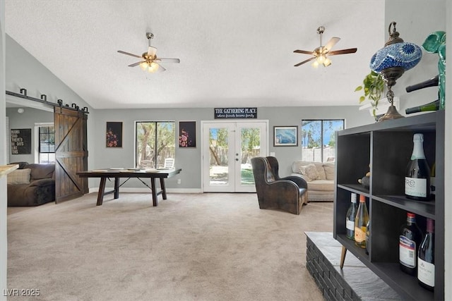 5008 Donnie Ave, Las Vegas, NV 89130 - living area with a barn door, vaulted ceiling, a ceiling fan, light carpet, and french doors
