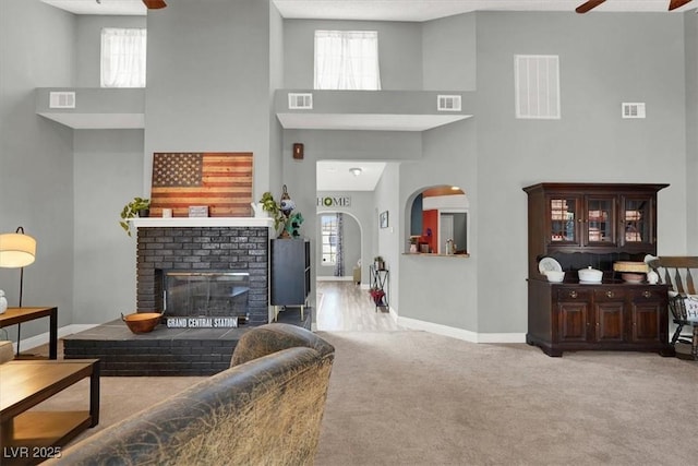 5008 Donnie Ave, Las Vegas, NV 89130 - carpeted living area with ceiling fan, a towering ceiling, and a fireplace