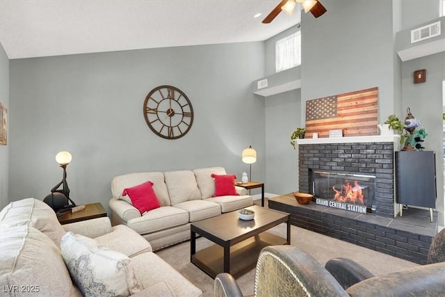 5008 Donnie Ave, Las Vegas, NV 89130 - carpeted living room with ceiling fan, a fireplace, and a towering ceiling