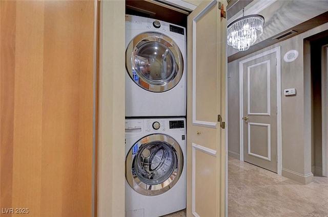 2877 Paradise Rd Unit 2105, Las Vegas, NV 89109 - laundry room with stacked washing machine and dryer and a chandelier