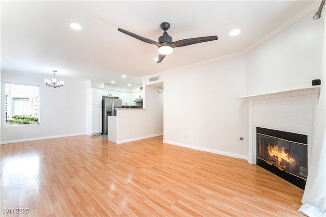 3060 Tarpon Dr Unit 104, Las Vegas, NV 89120 - unfurnished living room featuring crown molding, a chandelier, ceiling fan, a glass covered fireplace, and light wood-type flooring
