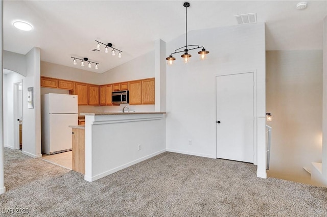 5521 Jackpot Winner Ln Unit 101, Las Vegas, NV 89122 - kitchen with freestanding refrigerator, stainless steel microwave, light carpet, light countertops, and lofted ceiling