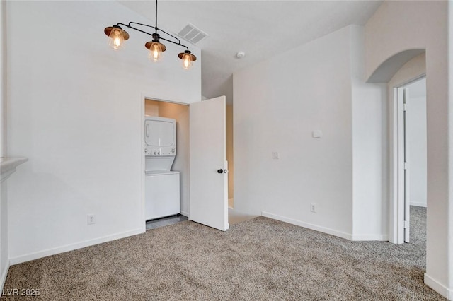 5521 Jackpot Winner Ln Unit 101, Las Vegas, NV 89122 - spare room with estacked washer and dryer, carpet floors, and arched walkways