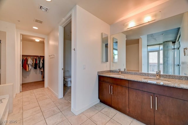 353 E Bonneville Ave Unit 313, Las Vegas, NV 89101 - bathroom featuring double vanity, tile patterned flooring, a walk in closet, a shower, and recessed lighting