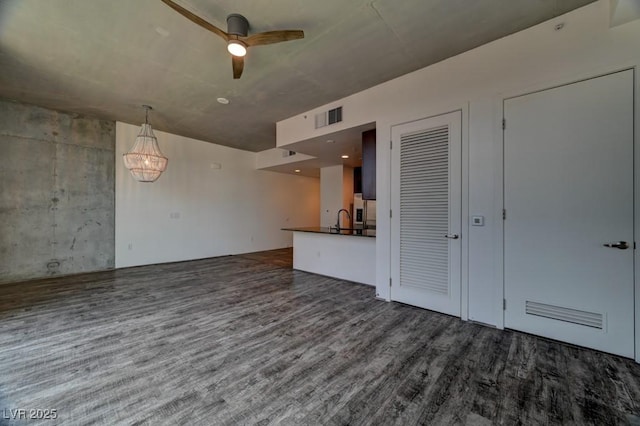 353 E Bonneville Ave Unit 313, Las Vegas, NV 89101 - unfurnished living room featuring wood finished floors, ceiling fan, and a chandelier