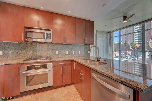 353 E Bonneville Ave Unit 313, Las Vegas, NV 89101 - kitchen with stainless steel appliances, tasteful backsplash, a ceiling fan, and brown cabinets