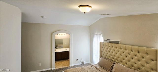 5045 Bayberry Crest St, North Las Vegas, NV 89031 - bedroom featuring vaulted ceiling, arched walkways, light carpet, and ensuite bath