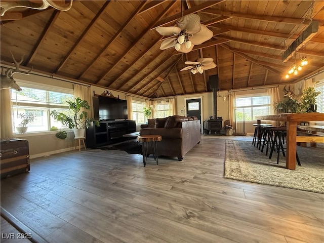 1829 Campton St, Ely, NV 89301 - living room with a wood stove, wood ceiling, hardwood / wood-style flooring, and a ceiling fan