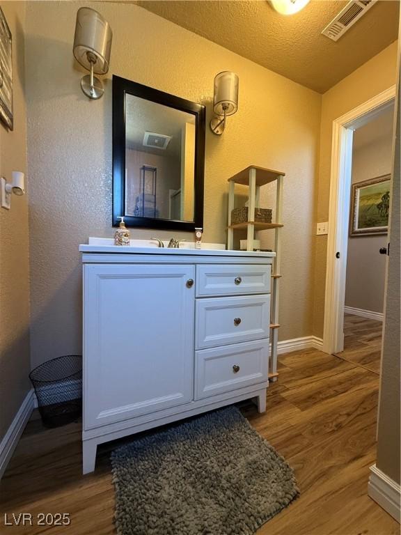 1829 Campton St, Ely, NV 89301 - bathroom with wood finished floors, vanity, and a textured wall