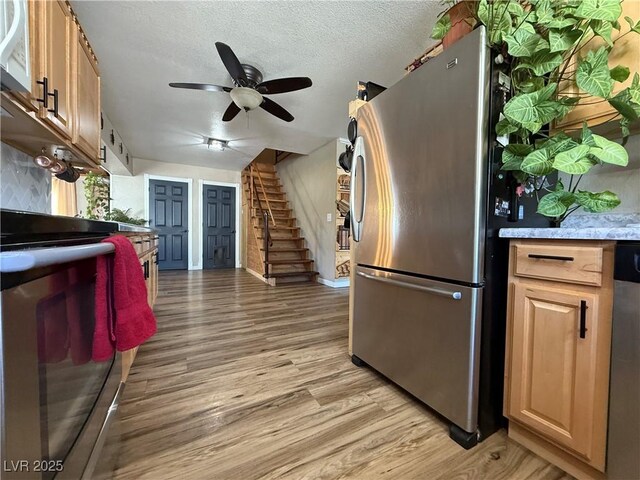 1829 Campton St, Ely, NV 89301 - kitchen with stainless steel appliances, light wood-style floors, a ceiling fan, and a textured ceiling