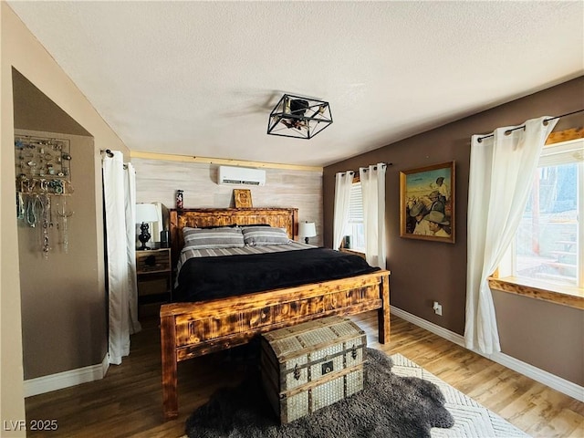 1829 Campton St, Ely, NV 89301 - bedroom featuring a wall unit AC, wood finished floors, and a textured ceiling