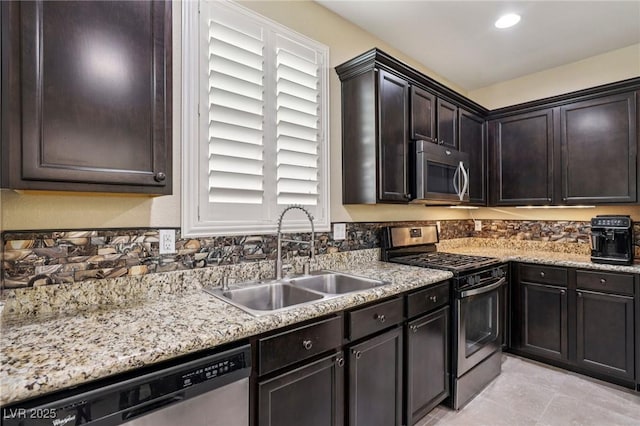 7407 Bakewell Ave, Las Vegas, NV 89179 - kitchen with appliances with stainless steel finishes, dark brown cabinets, light stone countertops, and recessed lighting