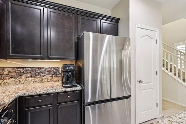 7407 Bakewell Ave, Las Vegas, NV 89179 - kitchen with freestanding refrigerator, light stone countertops, and dark brown cabinets