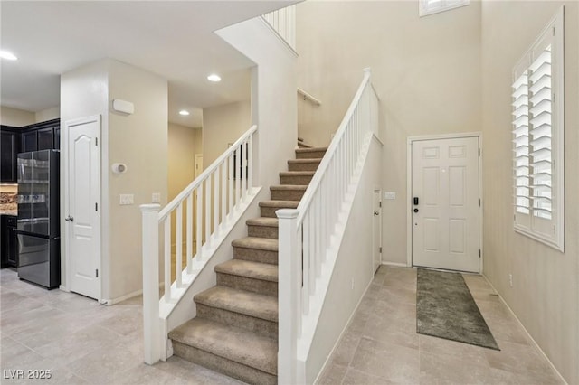 7407 Bakewell Ave, Las Vegas, NV 89179 - foyer entrance with stairs, recessed lighting, light tile patterned flooring, and a high ceiling