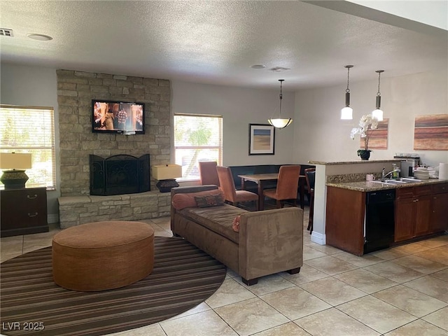 2750 S Durango Dr Unit 2141, Las Vegas, NV 89117 - living room featuring a textured ceiling, a stone fireplace, and light tile patterned flooring