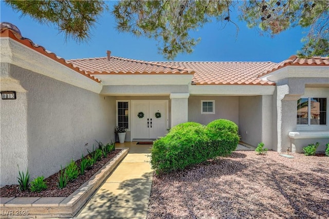 8813 Sundial Dr, Las Vegas, NV 89134 - view of exterior entry with a tile roof and stucco siding