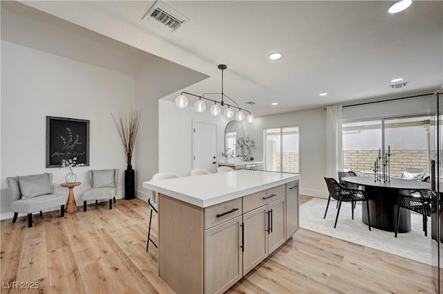 8813 Sundial Dr, Las Vegas, NV 89134 - kitchen featuring light wood-style flooring, a kitchen island, recessed lighting, light countertops, and decorative light fixtures