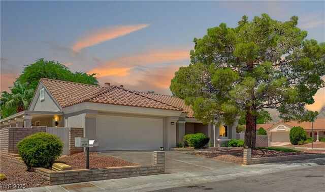 8813 Sundial Dr, Las Vegas, NV 89134 - mediterranean / spanish-style home featuring an attached garage, a tile roof, concrete driveway, and stucco siding