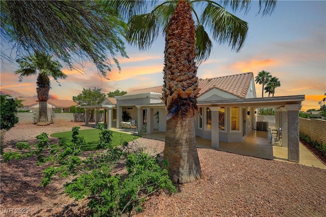 8813 Sundial Dr, Las Vegas, NV 89134 - rear view of property with a tile roof, a patio area, a fenced backyard, and stucco siding