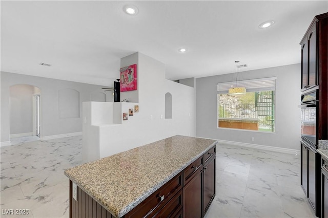 3079 Evening Mist Ave, Henderson, NV 89052 - kitchen featuring arched walkways, light marble finish flooring, open floor plan, recessed lighting, and a center island