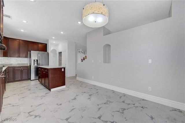3079 Evening Mist Ave, Henderson, NV 89052 - kitchen featuring stainless steel fridge with ice dispenser, light marble finish flooring, a kitchen island, light countertops, and recessed lighting