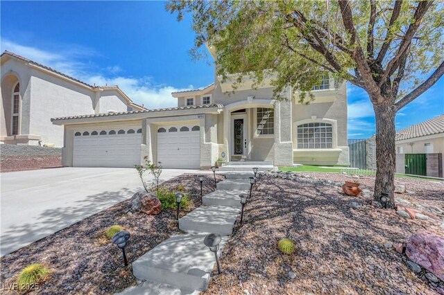 3079 Evening Mist Ave, Henderson, NV 89052 - mediterranean / spanish house featuring a garage, stucco siding, driveway, and a tiled roof