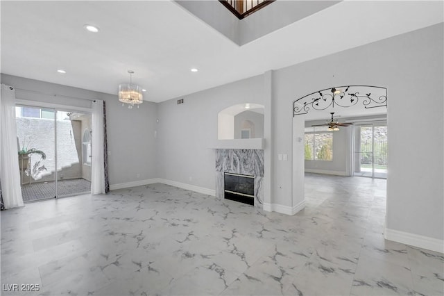 3079 Evening Mist Ave, Henderson, NV 89052 - unfurnished living room featuring plenty of natural light, recessed lighting, a premium fireplace, light marble finish flooring, and a chandelier