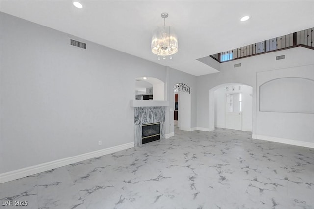 3079 Evening Mist Ave, Henderson, NV 89052 - unfurnished living room with arched walkways, marble finish floors, a chandelier, recessed lighting, and a high end fireplace