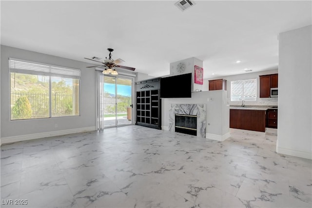 3079 Evening Mist Ave, Henderson, NV 89052 - unfurnished living room featuring ceiling fan, a fireplace, light marble finish floors, and recessed lighting