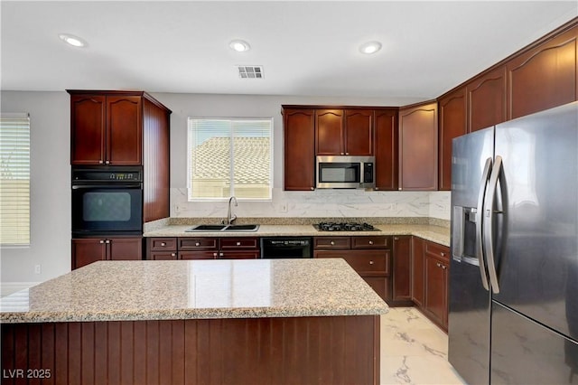 3079 Evening Mist Ave, Henderson, NV 89052 - kitchen featuring black appliances, light marble finish floors, backsplash, a kitchen island, and light stone countertops