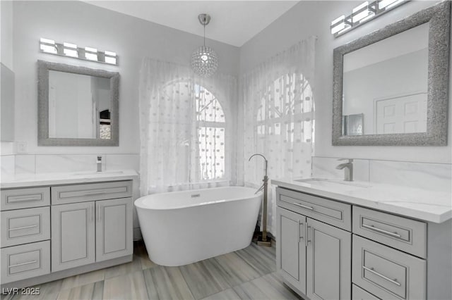 3079 Evening Mist Ave, Henderson, NV 89052 - bathroom with two vanities, a freestanding bath, and a chandelier