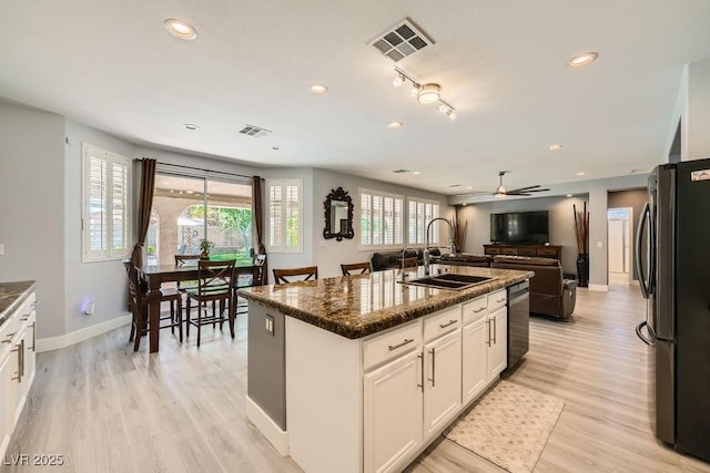 6103 Sundown Crest St, Las Vegas, NV 89113 - kitchen with freestanding refrigerator, a kitchen island with sink, light wood-style floors, recessed lighting, and white cabinets