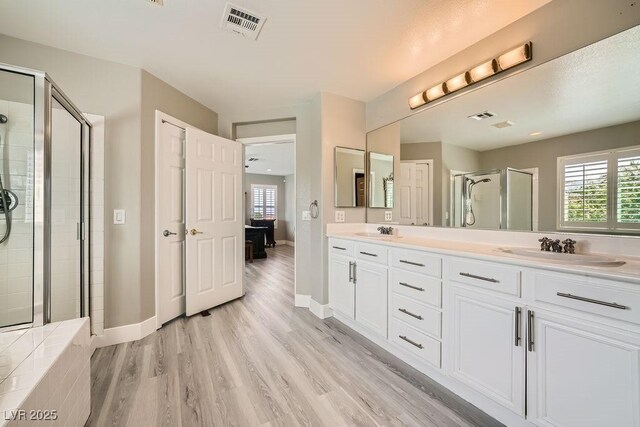 6103 Sundown Crest St, Las Vegas, NV 89113 - bathroom featuring double vanity, a stall shower, and wood finished floors