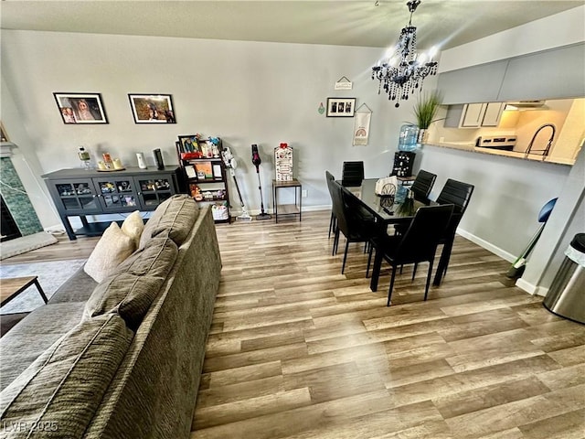 2016 Mesquite Ln Unit 302, Laughlin, NV 89029 - dining area with a chandelier, light wood finished floors, and a fireplace with raised hearth