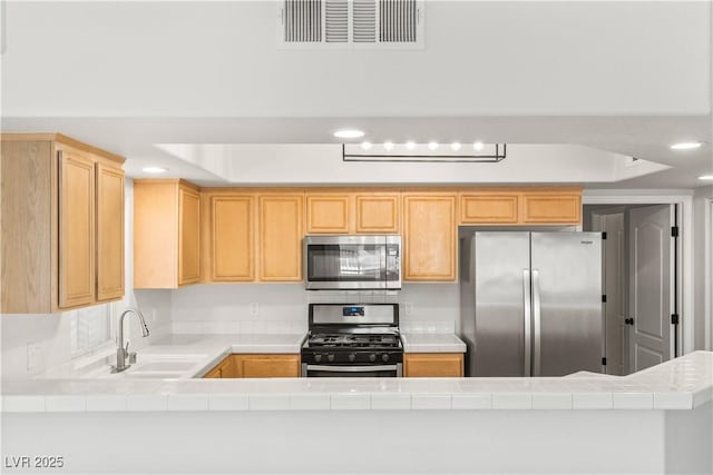 3608 Quetonia St Unit 204, Las Vegas, NV 89108 - kitchen featuring stainless steel appliances, tile countertops, light brown cabinetry, a tray ceiling, and recessed lighting